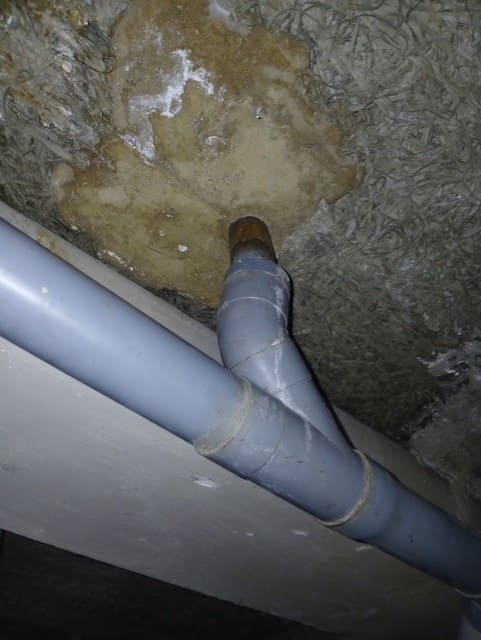 Piquage d’une évacuation en PVC sur une canalisation existante, en cave.