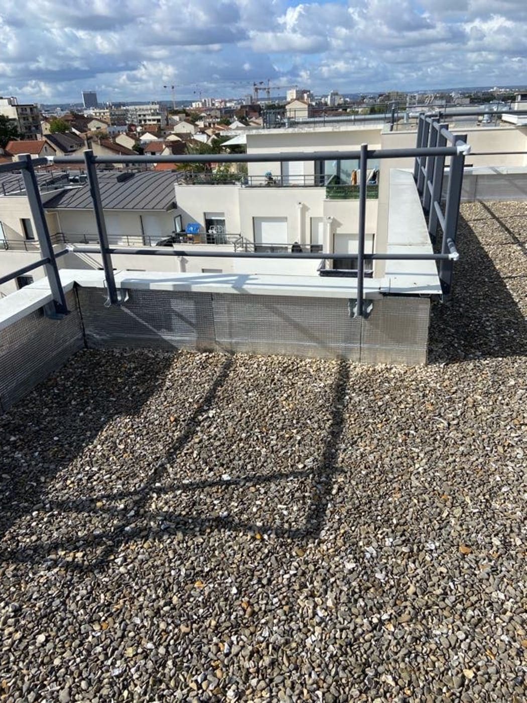 Toiture-terrasse avec garde-corps et acrotère, vue d’ensemble.