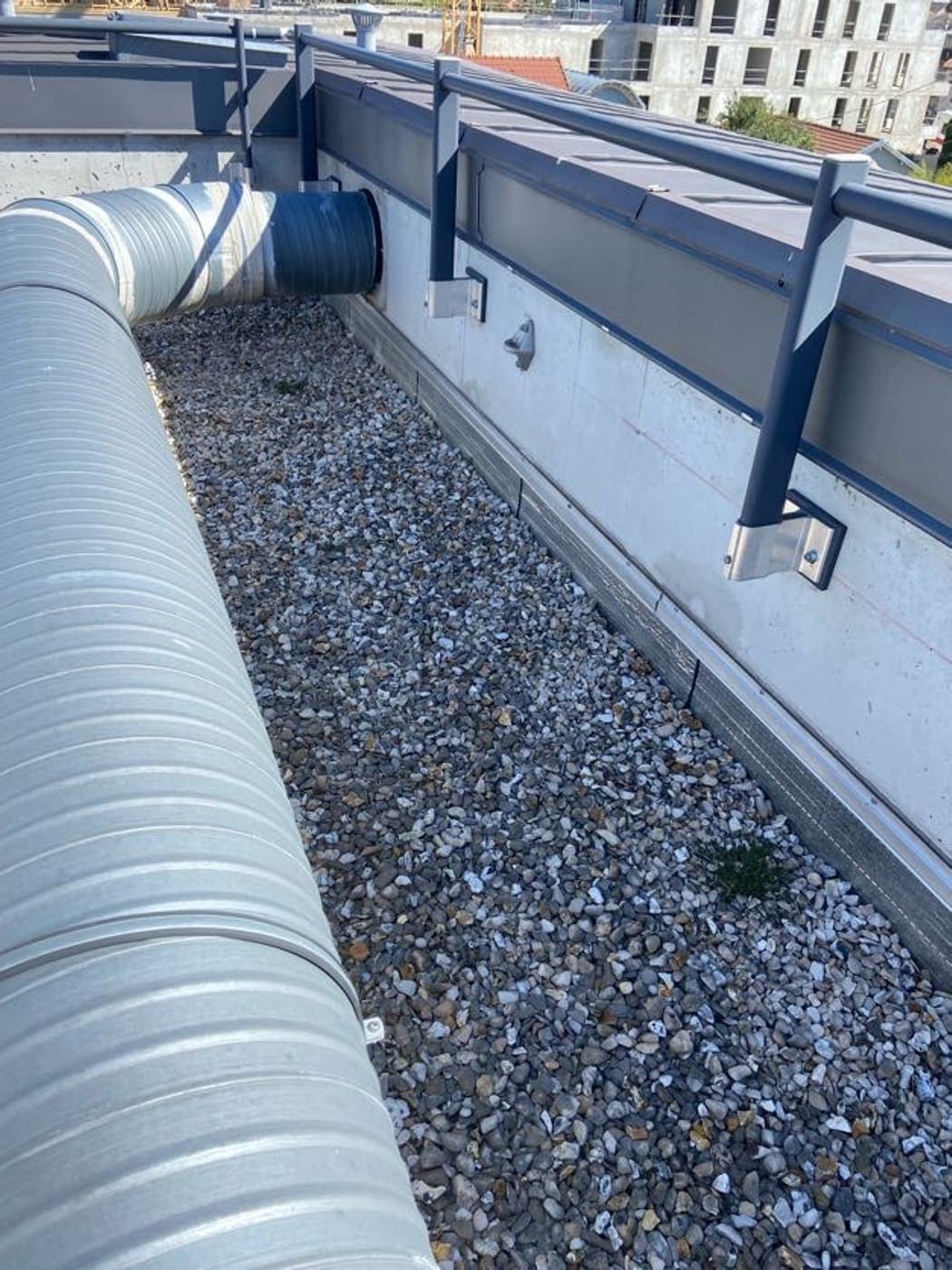 Toiture-terrasse protégée par un lit de gravillons, en pied de relevé d’étanchéité.