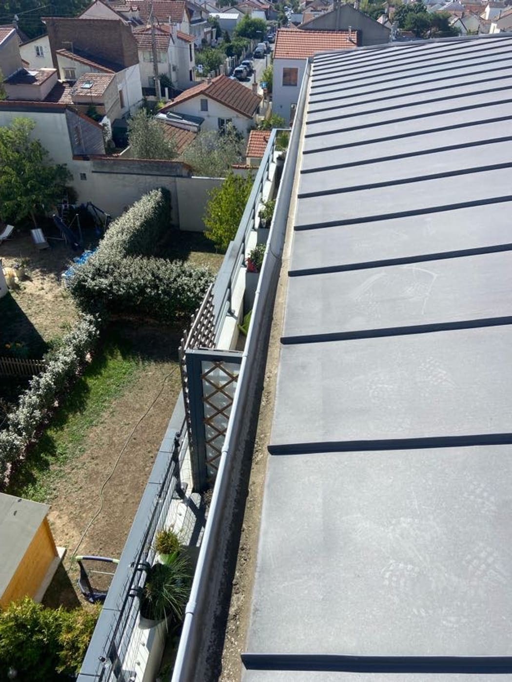 Rive de toiture en zinc à joint debout et son chéneau, vue depuis le toit.